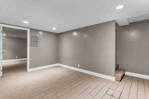 Finished basement featuring recessed lighting, wood tiled floors, and electric panel