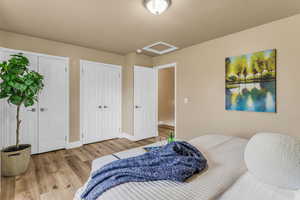 Bedroom featuring wood finished floors and multiple closets