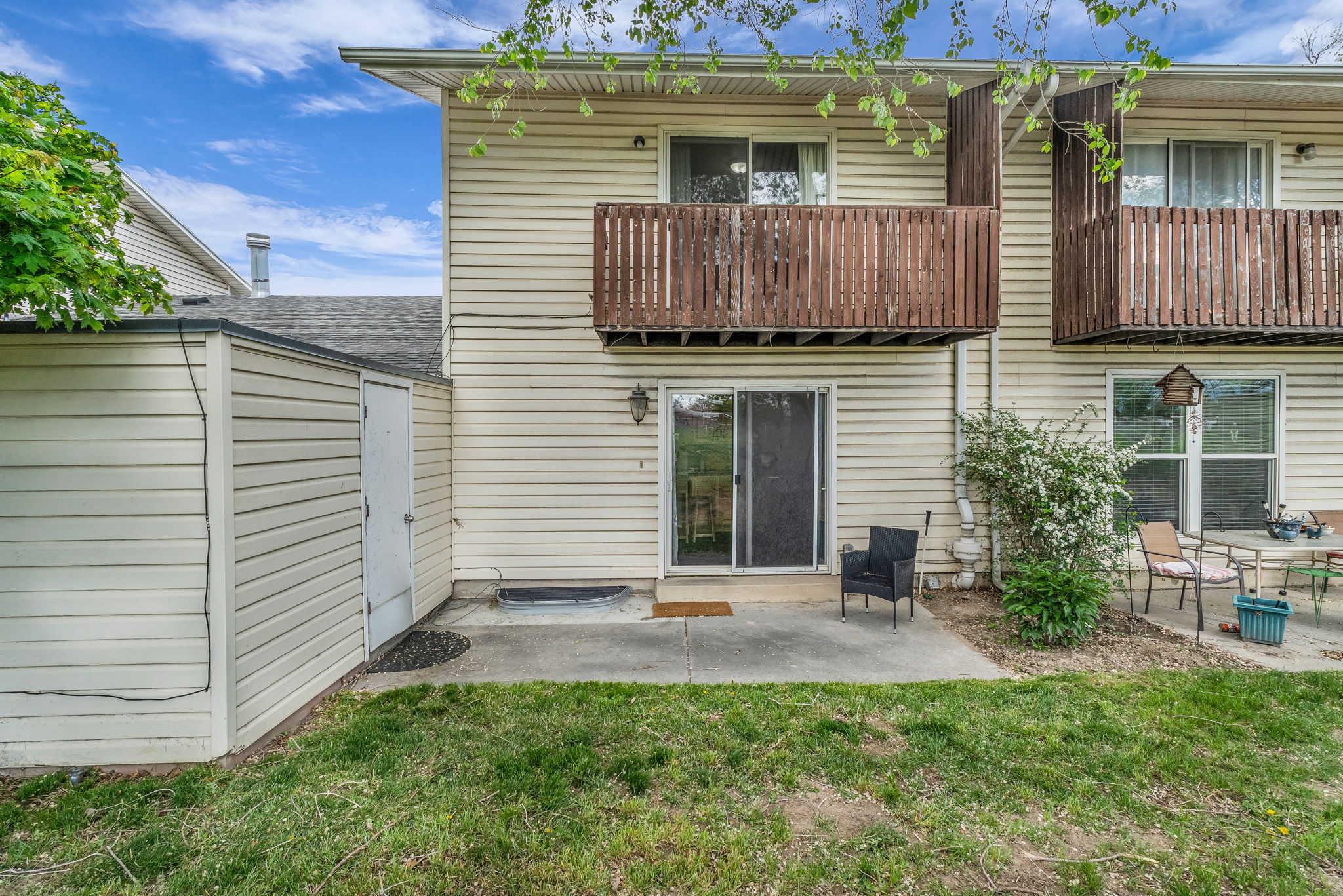 Rear view of property featuring a balcony, a patio area, and a yard