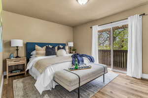Bedroom with access to outside and wood finished floors