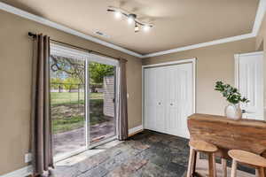 Dining room featuring stone tile floors and ornamental molding