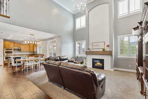 Living room with a chandelier, a fireplace, and a high ceiling