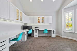 Office with vaulted ceiling, built in study area, dark carpet, and recessed lighting