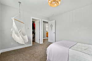 Bedroom with a spacious closet and carpet