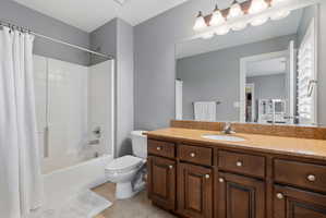 Bathroom featuring vanity, shower / bath combo, and light tile patterned floors