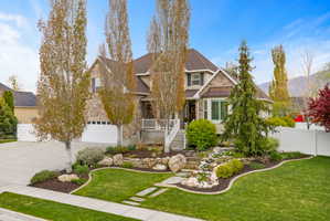 View of front of property with stone siding, concrete driveway, and roof with shingles