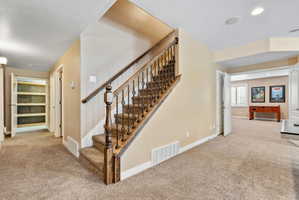 Stairway with carpet floors and recessed lighting