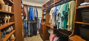 Walk in closet featuring light colored carpet