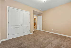 Unfurnished bedroom with a closet and carpet flooring