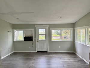 Doorway to outside featuring wood-style floors and cooling unit