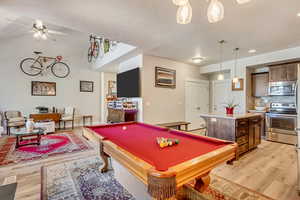 Rec room featuring light wood-style flooring, billiards, and a ceiling fan