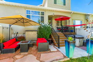 View of front of house featuring a patio area, stucco siding, and an outdoor living space with a fire pit