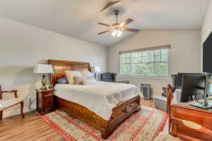 Bedroom featuring light wood-style flooring, lofted ceiling, and ceiling fan