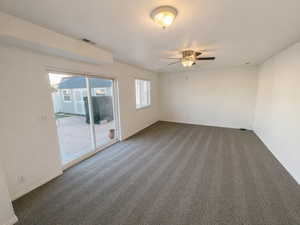 Carpeted empty room featuring baseboards and ceiling fan