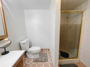 Full bath featuring a shower stall, vanity, and light tile patterned floors