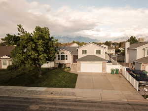 View of front facade featuring concrete driveway, brick siding, and a residential view