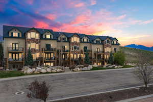 View of front of property with stone siding, a balcony, and a mountain view