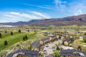 Aerial view of residential area featuring a mountainous background and a local golf course