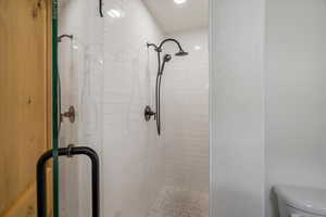 Full bathroom featuring a stall shower and toilet