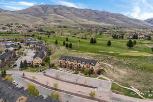Aerial perspective of suburban area featuring a mountainous background and a local golf course