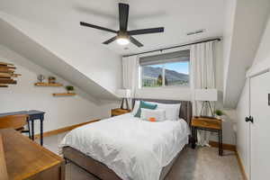 Bedroom featuring a mountain view, light carpet, and ceiling fan