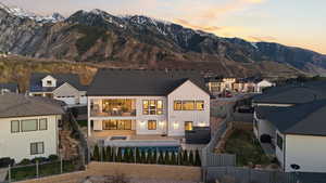 Back of house featuring a fenced backyard, board and batten siding, a patio, a mountain view, and a residential view