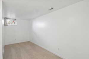 Unfurnished room featuring baseboards and light colored carpet
