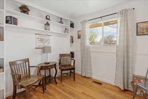 Living area with built in features and light wood-style floors