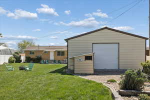 Rear view of property with an outdoor structure and an outdoor fire pit