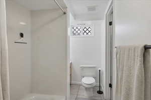 Bathroom with vanity, light tile patterned floors, and curtained shower