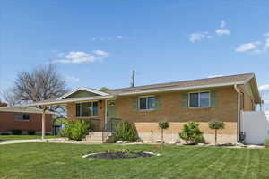 Ranch-style house featuring brick siding and a carport