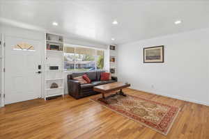 Living area with light wood-style floors and recessed lighting