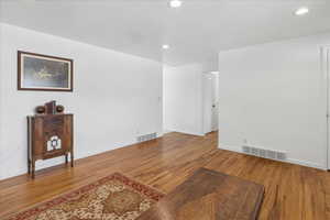 Unfurnished living room with wood finished floors and recessed lighting