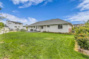 Rear view of house with a fenced backyard, a patio, and roof with shingles