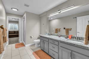 Full bath featuring double vanity, a stall shower, and light tile patterned floors