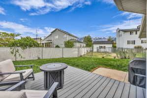 Wooden deck with a fenced backyard, a grill, and a mountain view