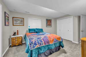 Bedroom with light carpet and a closet
