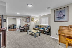 Living area featuring a desk and light colored carpet