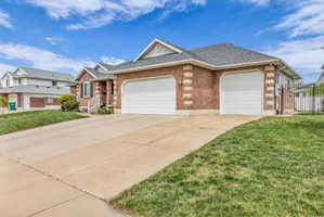 Single story home featuring a shingled roof, an attached garage, brick siding, and driveway