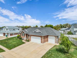 View of front of property with an attached garage, brick siding, driveway, roof with shingles, and a residential view