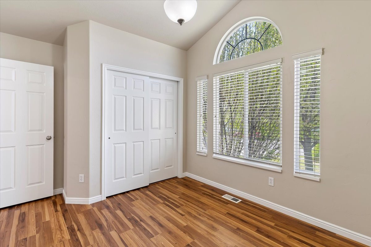 Bedroom featuring a closet, lofted ceiling, and wood finished floors