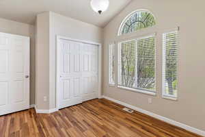 Bedroom featuring a closet, lofted ceiling, and wood finished floors