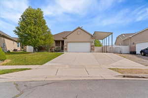 View of front facade with a garage, stucco siding, a front lawn, and concrete driveway