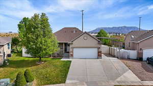 View of front of property featuring stucco siding, a residential view, an attached garage, concrete driveway, and a gate