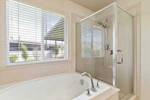 Primary bathroom with a stall shower and a garden tub