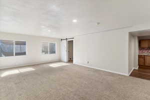 Family Room with carpet flooring, a barn door, a textured ceiling, and recessed lighting