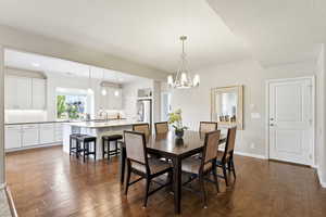 Dining area featuring dark wood-type flooring and hanging lights