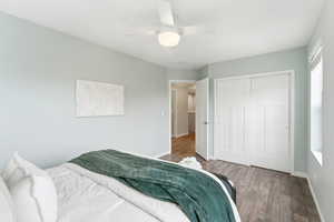 Bedroom featuring dark wood-style floors, ceiling fan, and a closet