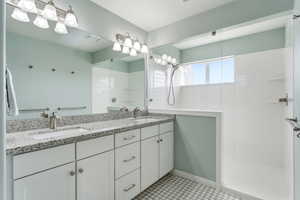 Bathroom featuring double vanity and a walk in shower