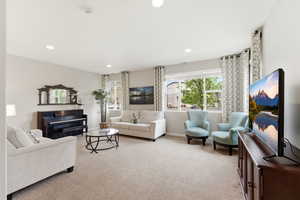 Living room with plenty of natural light, light carpet, and recessed lighting